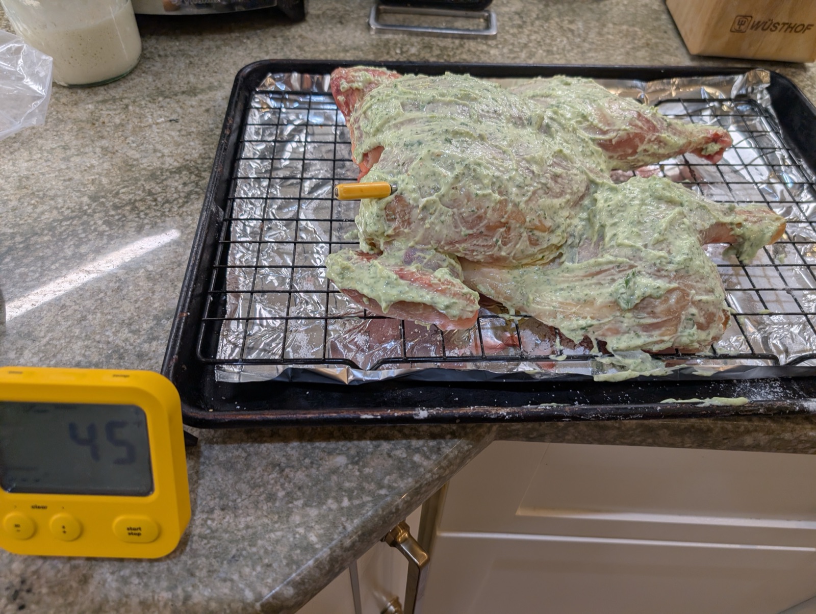 Chicken coated in the herb mayo with the thermometer probe inserted